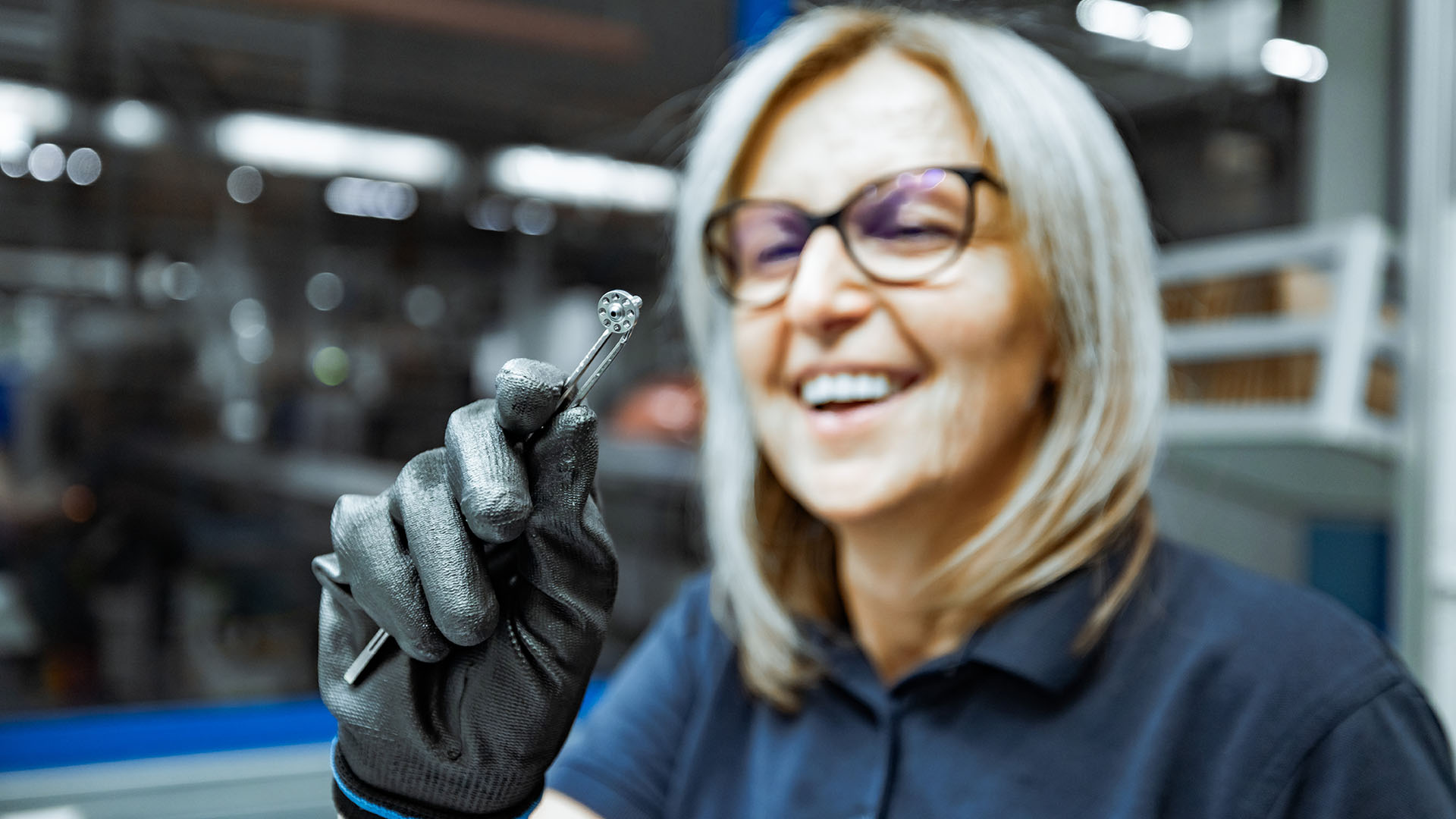 Employee proudly displaying a turned part to the camera